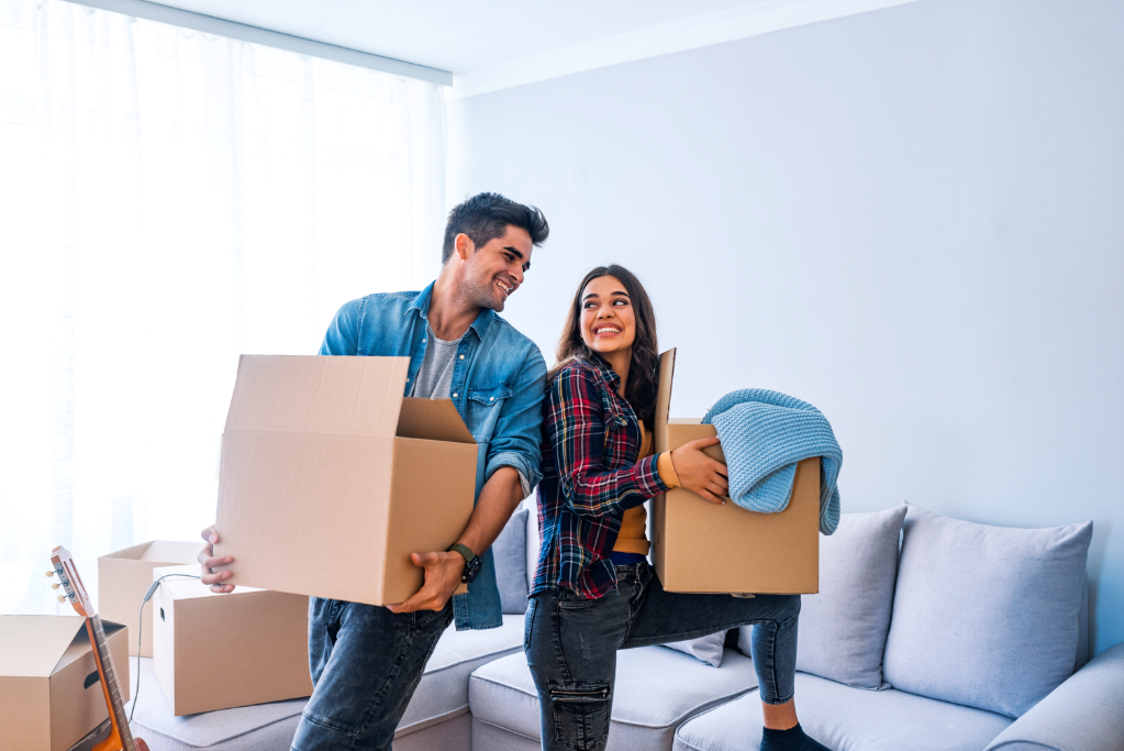 Young couple moving into new home with cardboard boxes