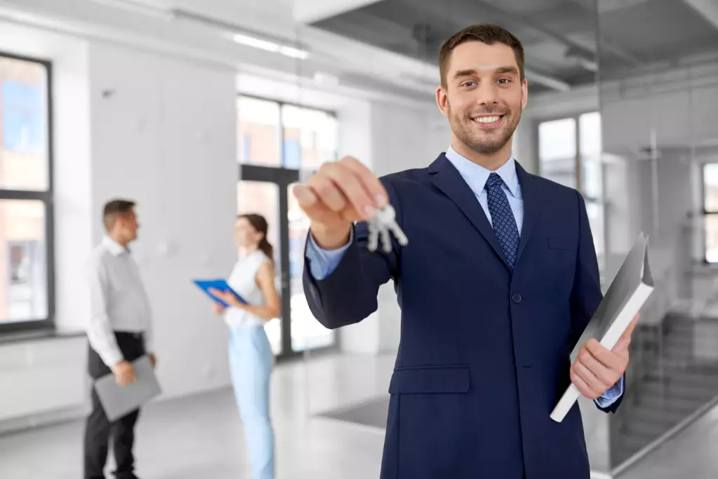 Real estate business, sale and people concept - smiling realtor with keys and folder and customers at new office